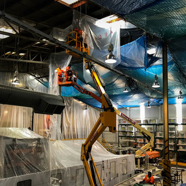 Debris and asbestos containment system incorporating fall arrest safety nets in live processing plant